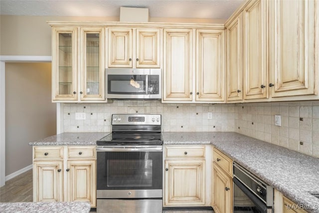 kitchen featuring wood-type flooring, appliances with stainless steel finishes, and decorative backsplash