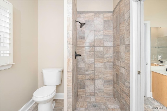 bathroom featuring vanity, toilet, and a tile shower