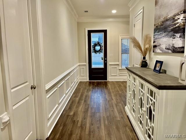 doorway to outside featuring crown molding and dark hardwood / wood-style flooring