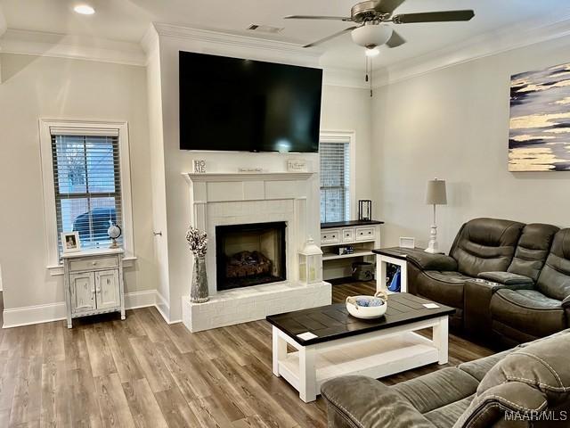 living room featuring hardwood / wood-style flooring, ornamental molding, and ceiling fan