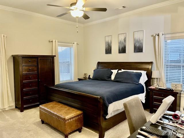 bedroom featuring crown molding, light colored carpet, and ceiling fan