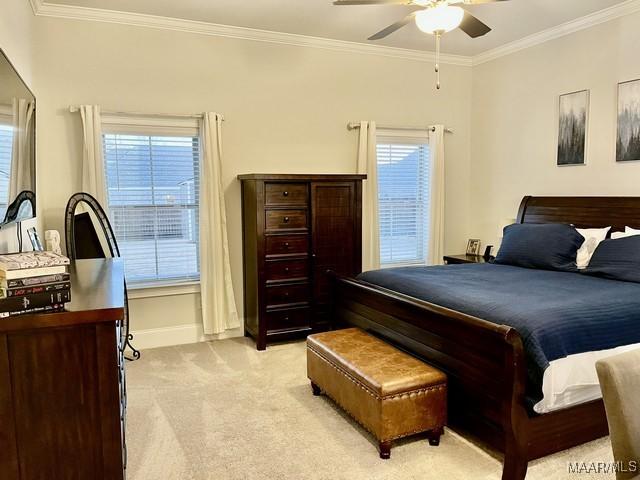 bedroom with crown molding, ceiling fan, and light carpet