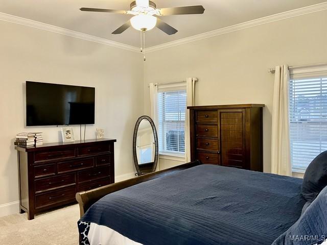 bedroom with crown molding, ceiling fan, and light carpet