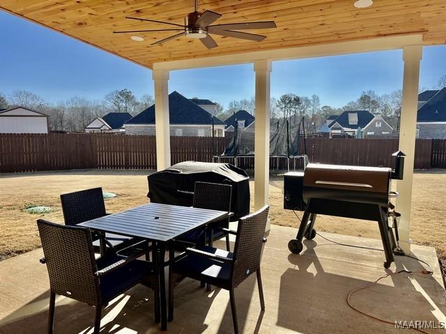 view of patio with a trampoline, a grill, and ceiling fan