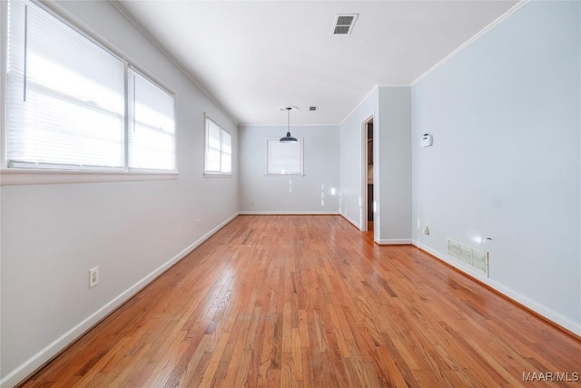 empty room featuring ornamental molding and light hardwood / wood-style floors