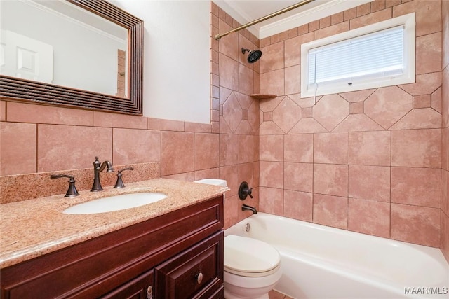 full bathroom with tiled shower / bath, tile walls, vanity, and toilet