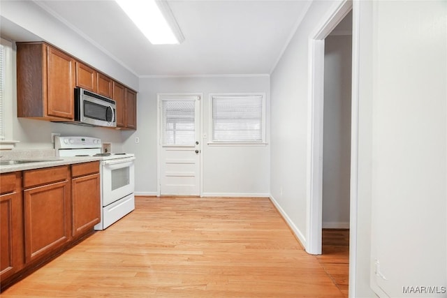 kitchen featuring ornamental molding, white electric stove, sink, and light hardwood / wood-style flooring