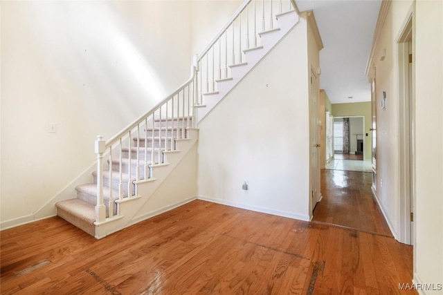 stairway with a high ceiling and hardwood / wood-style floors