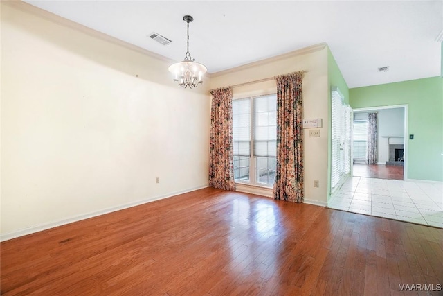 empty room with wood-type flooring and a chandelier