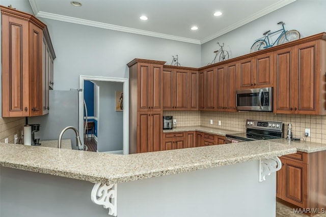 kitchen with stainless steel appliances, light stone countertops, a breakfast bar area, and kitchen peninsula