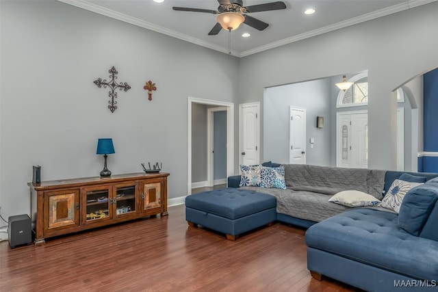 living room featuring hardwood / wood-style flooring, ornamental molding, a high ceiling, and ceiling fan