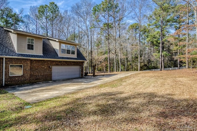 view of side of home featuring a garage and a yard