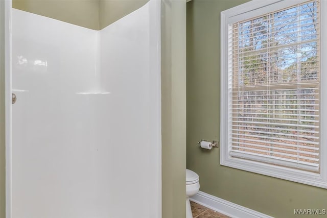 bathroom featuring a healthy amount of sunlight, tile patterned floors, and toilet