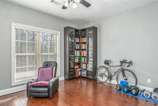 sitting room with dark wood-type flooring and ceiling fan