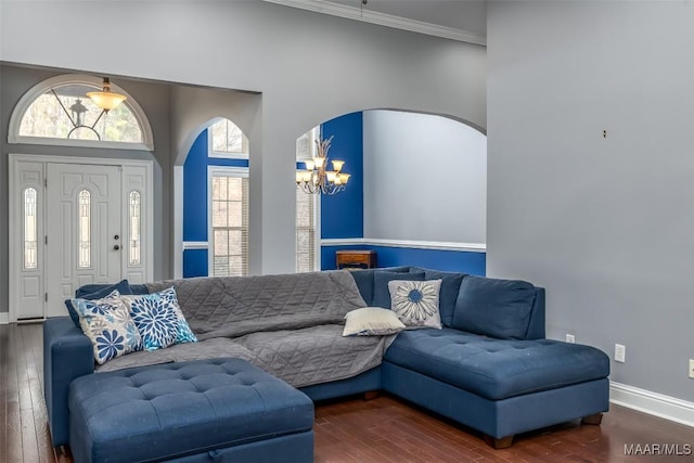 living room featuring a notable chandelier, ornamental molding, and dark hardwood / wood-style floors