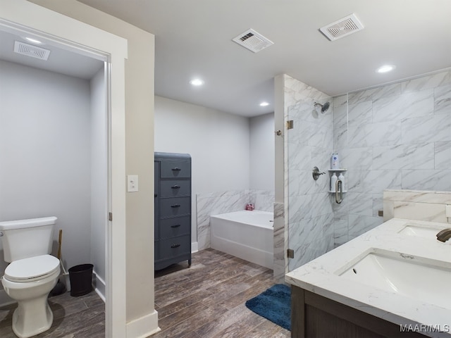 full bathroom with toilet, wood-type flooring, tile walls, vanity, and independent shower and bath