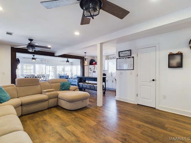 living room featuring dark hardwood / wood-style flooring, sink, and beam ceiling