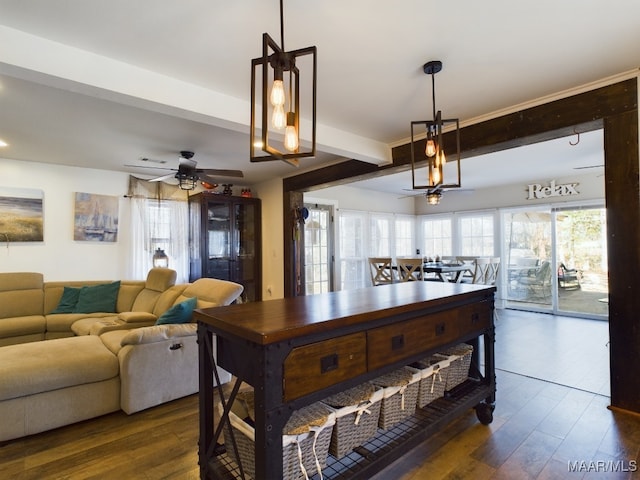 dining space featuring dark hardwood / wood-style flooring, ceiling fan, and beamed ceiling