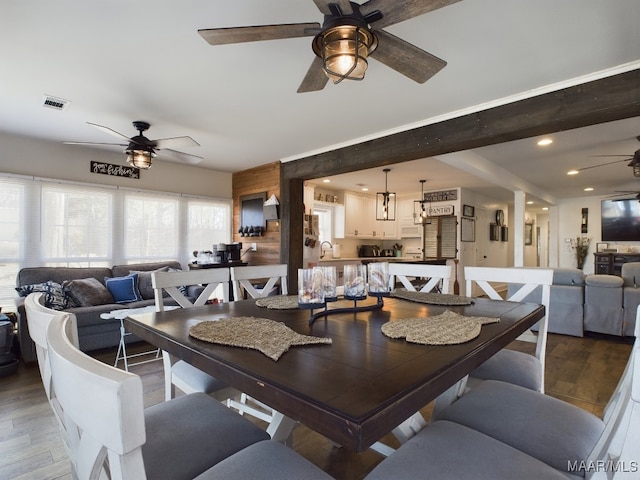 dining area with hardwood / wood-style flooring, ceiling fan, and sink