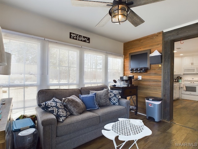 living room featuring ceiling fan, dark hardwood / wood-style flooring, and wood walls