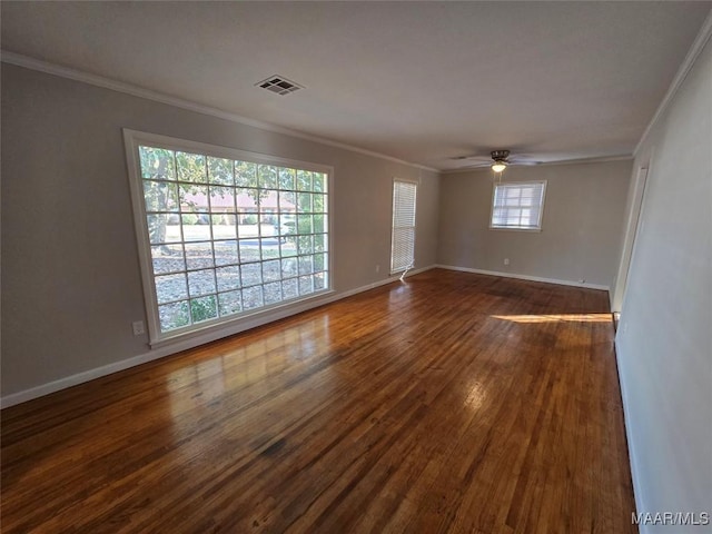 unfurnished room with ornamental molding, dark wood-type flooring, visible vents, and baseboards