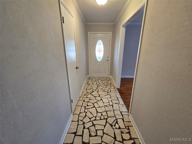 doorway featuring crown molding, a textured wall, and baseboards