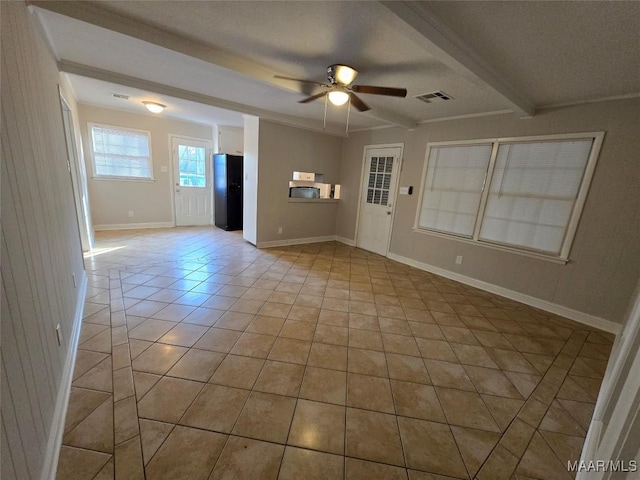 empty room featuring visible vents, light tile patterned flooring, ceiling fan, beamed ceiling, and baseboards