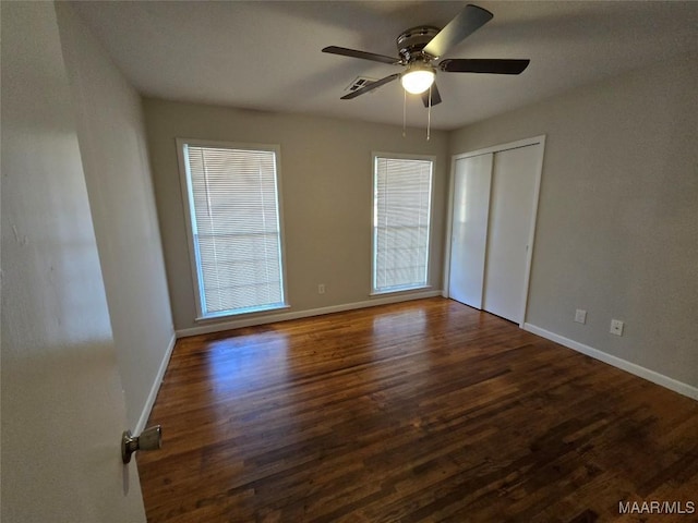 unfurnished room featuring dark wood-type flooring and ceiling fan