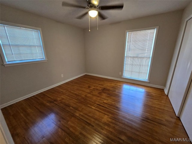 empty room featuring ceiling fan, wood finished floors, and baseboards