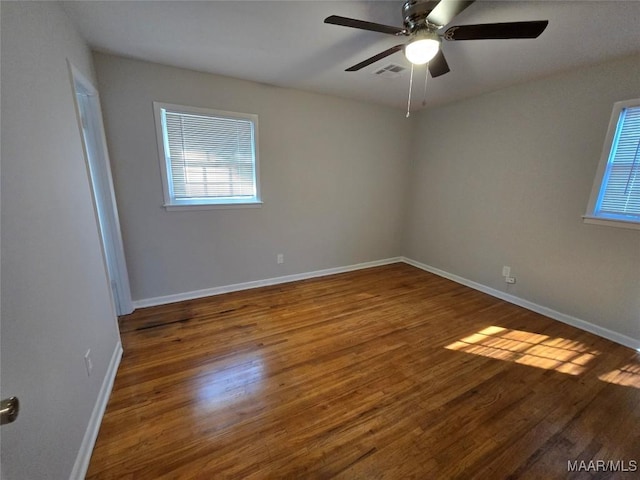 empty room featuring dark hardwood / wood-style flooring and ceiling fan