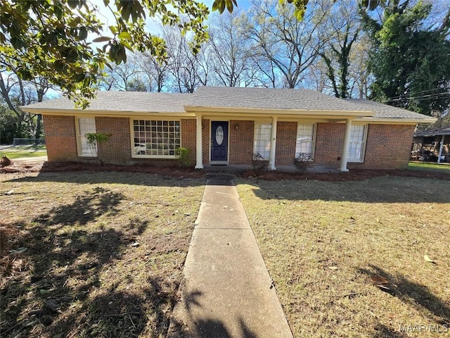 ranch-style home featuring a front yard and brick siding