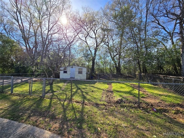 view of yard with an outdoor structure, a fenced backyard, and a gate