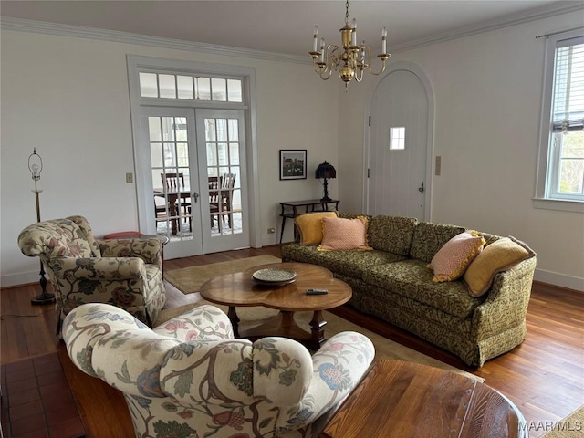 living room featuring french doors, ornamental molding, an inviting chandelier, and hardwood / wood-style floors