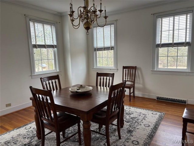 dining room featuring ornamental molding, a wealth of natural light, and hardwood / wood-style floors