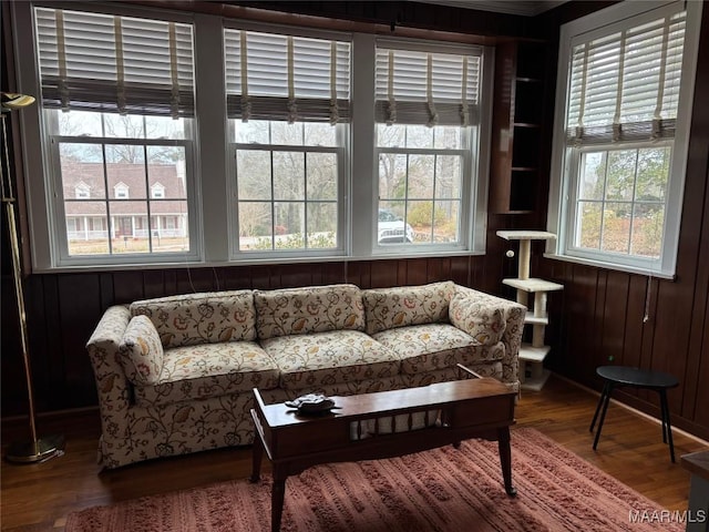 living area with wood-type flooring and wooden walls