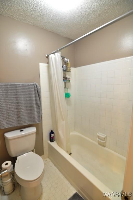 bathroom with shower / tub combo, a textured ceiling, and toilet