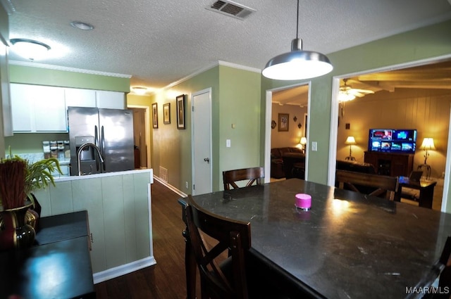 kitchen with a textured ceiling, stainless steel fridge, dark hardwood / wood-style flooring, pendant lighting, and white cabinets