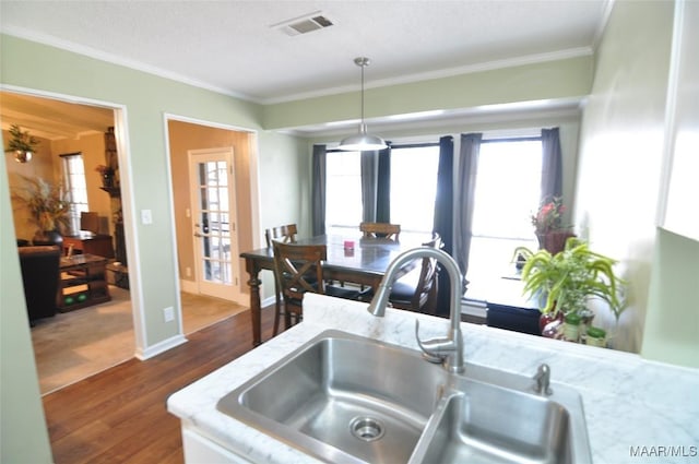 kitchen featuring sink, decorative light fixtures, ornamental molding, and dark hardwood / wood-style floors