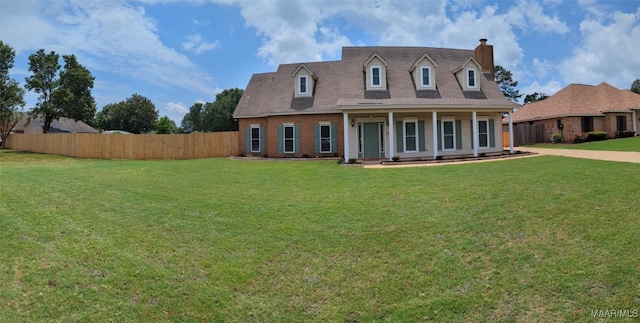 new england style home with a front yard and covered porch