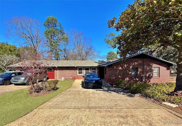 ranch-style home featuring a garage and a front lawn