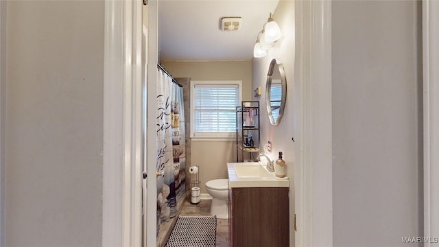 bathroom with vanity, toilet, and curtained shower