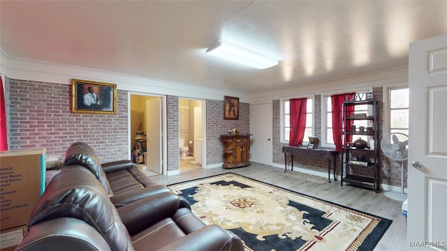 living room featuring light hardwood / wood-style floors and brick wall