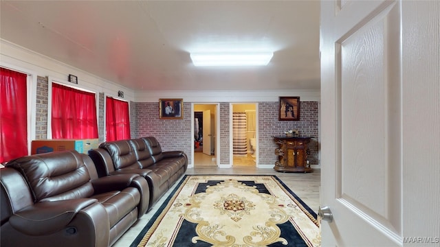 living room with hardwood / wood-style flooring and brick wall