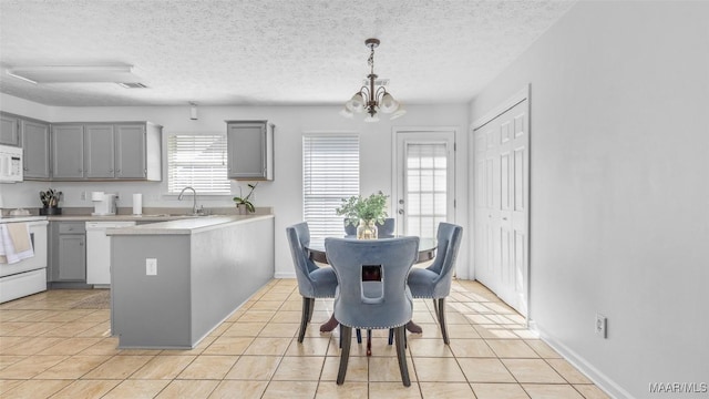 kitchen with white appliances, sink, hanging light fixtures, and gray cabinetry