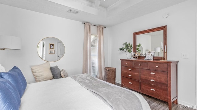 bedroom featuring wood-type flooring and a raised ceiling