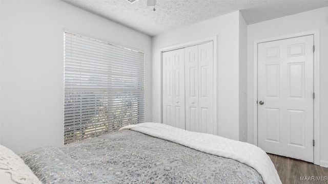 bedroom featuring ceiling fan, dark hardwood / wood-style floors, a textured ceiling, and a closet