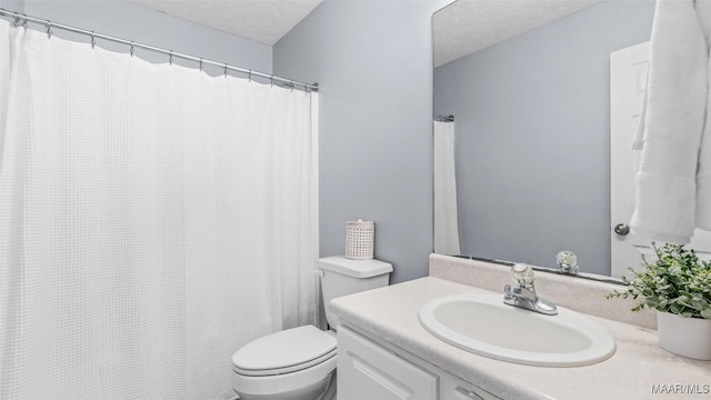 bathroom with vanity, a textured ceiling, and toilet