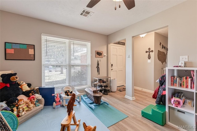 rec room featuring ceiling fan, hardwood / wood-style floors, and a textured ceiling