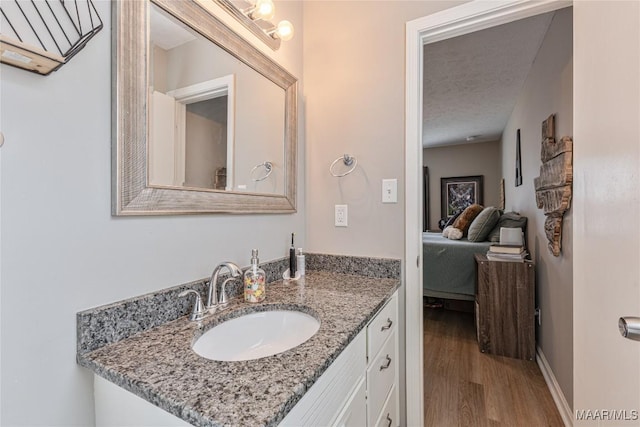 bathroom with vanity, wood-type flooring, and a textured ceiling