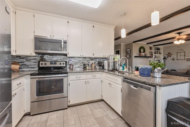 kitchen with decorative light fixtures, white cabinets, and appliances with stainless steel finishes